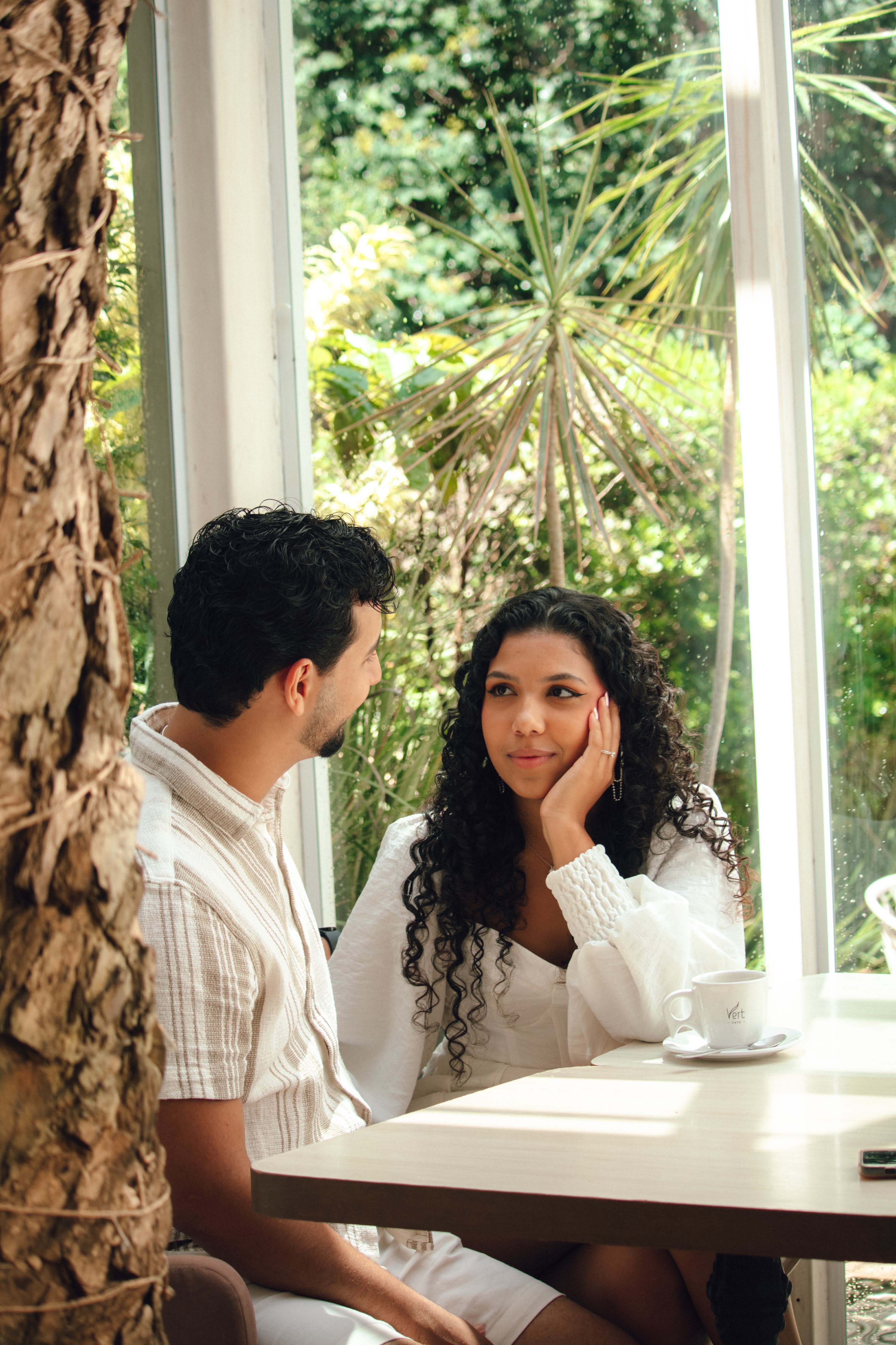 Emanuel e Melissa compartilhando um momento em um café aconchegante
